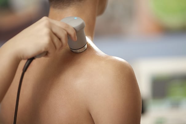Man receiving ultrasound treatment on his back and shoulder