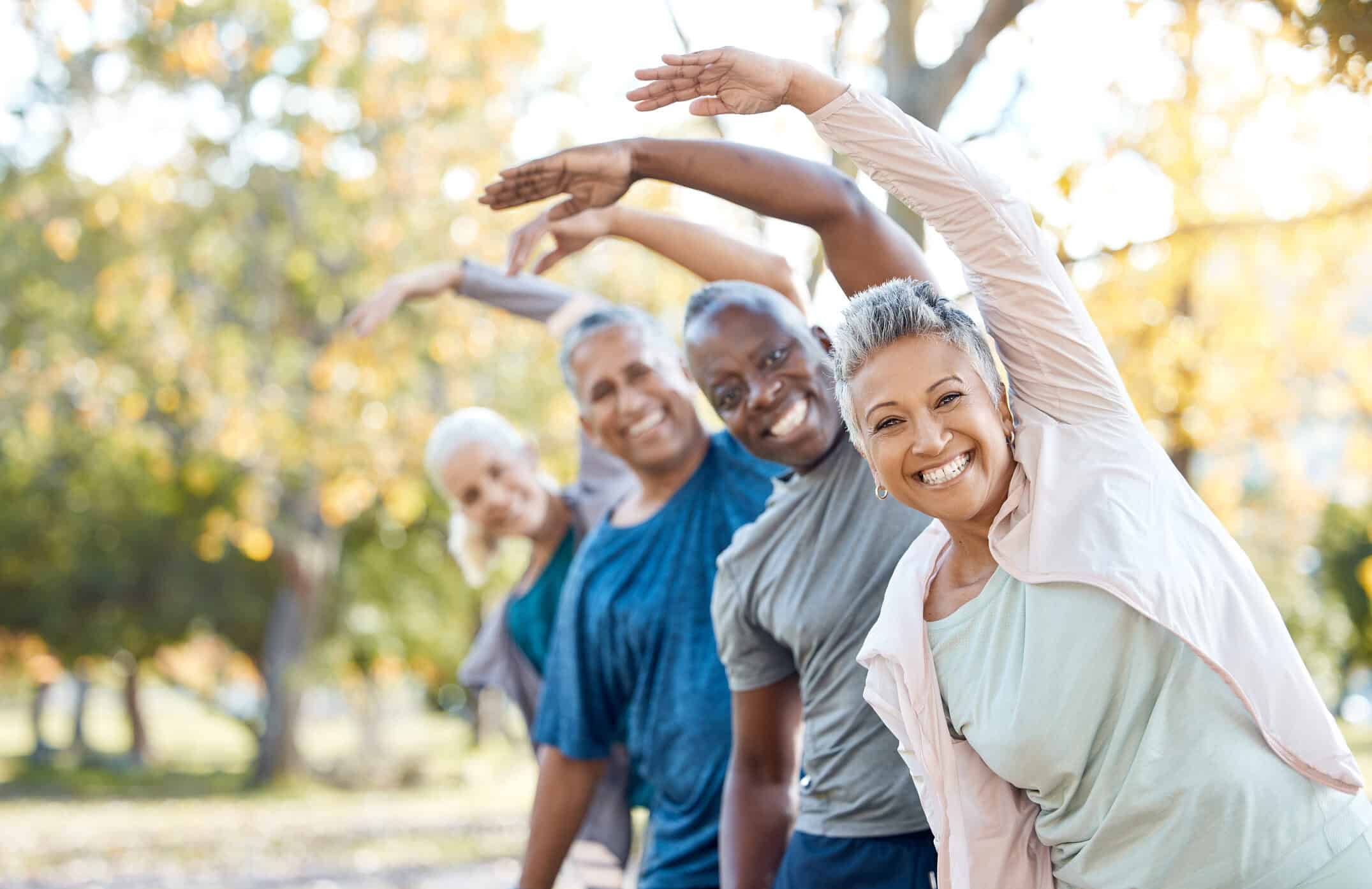 Senior people yoga-stretching in park for muscle health, workout and training with retirement community.