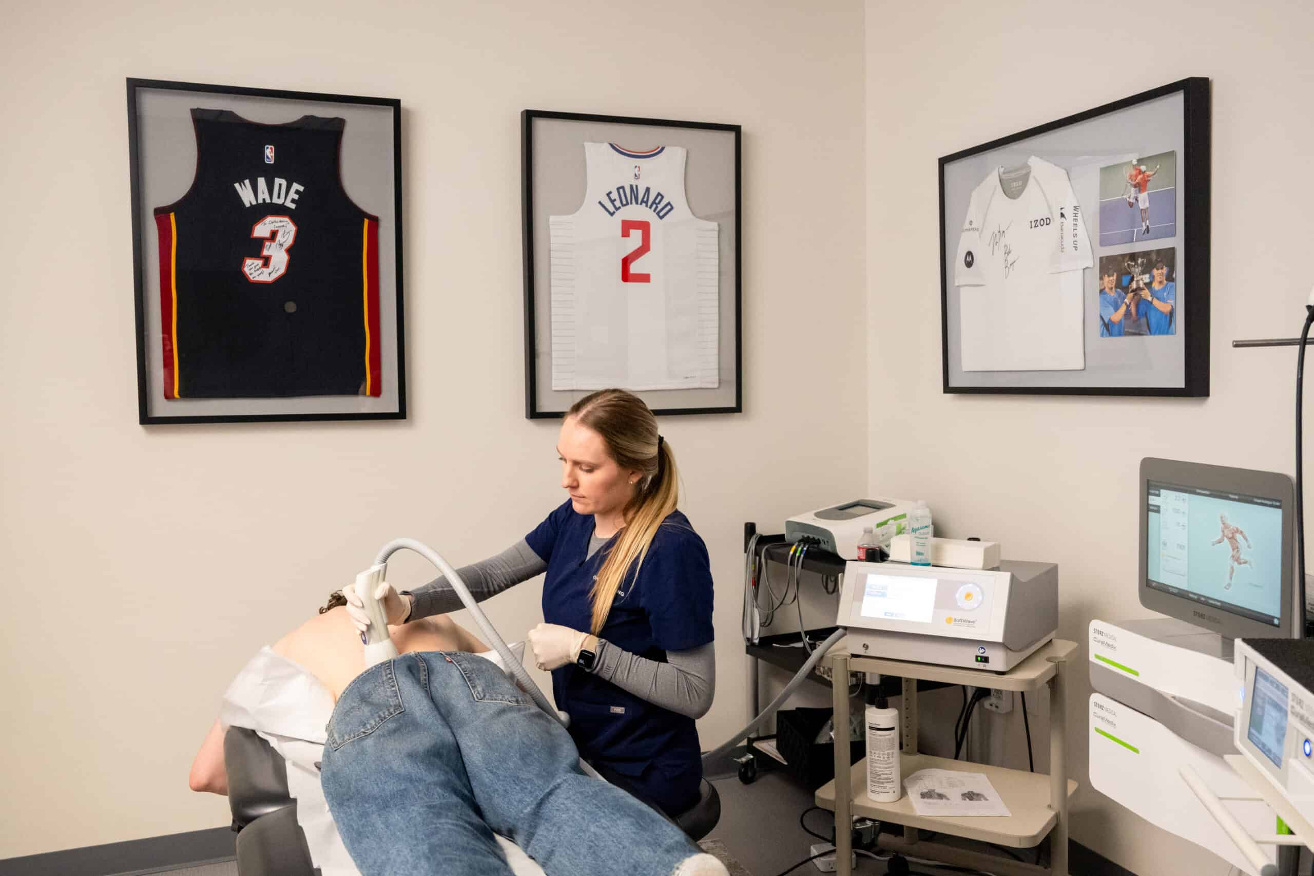 Orthohealing medical employee performing shockwave therapy for chronic back pain relief